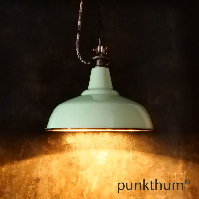 Apfelgrüne Emaillelampe, Industrielampe mit Stahlguss-Aufhängung und Textilkabel, eingeschaltet.