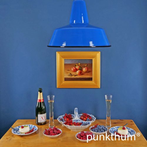 Große blaue Emaillelampe über dem Tisch.